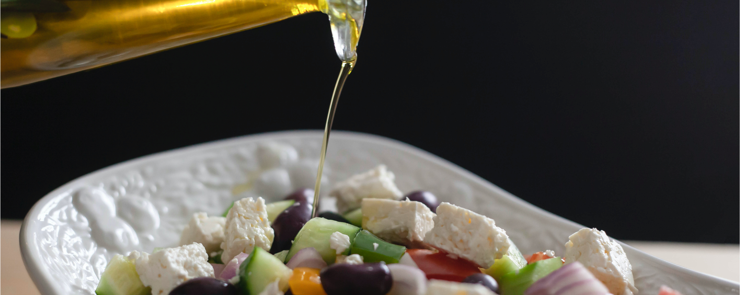 Golden Veliotiko Oil Pouring Over Greek Salad